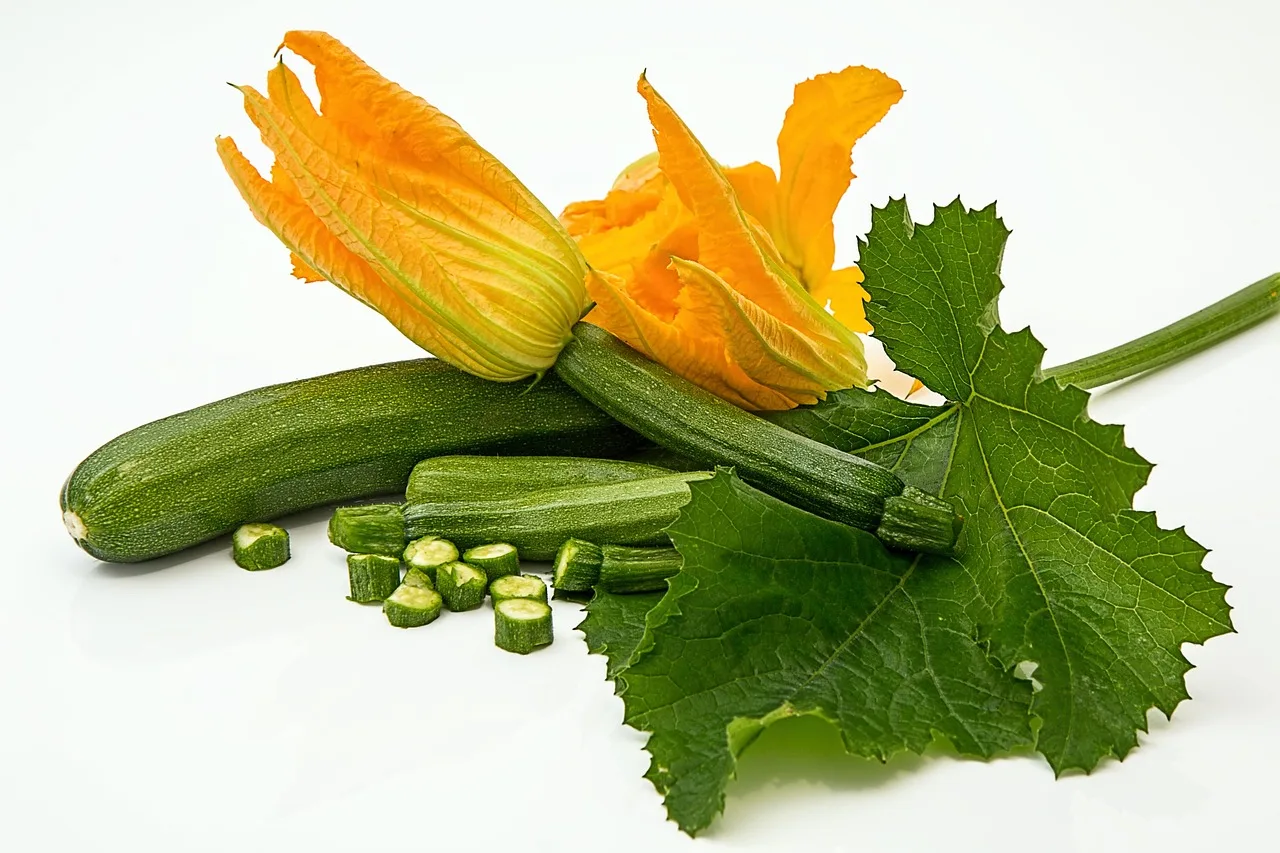 Zucchine fresche tagliate a fette pronte per la cottura, con ingredienti salutari sul tavolo.